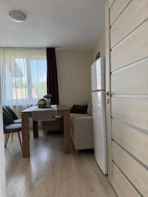a kitchen with a table and a refrigerator in a room at The Walnut Nest in Sapareva Banya