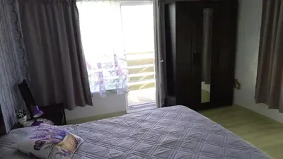 a bedroom with a bed and a large window at Бутикови стаи за гости- Felicita in Kyustendil
