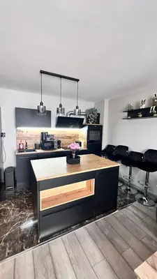 a kitchen with a counter and some black chairs at Апартамент за гости Noa Sift in Velingrad