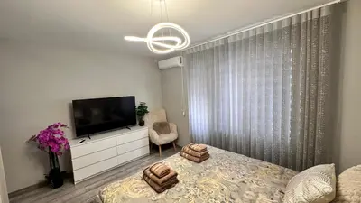 a bedroom with a bed and a flat screen tv at Апартамент за гости Noa Sift in Velingrad