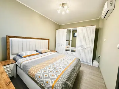 a bedroom with a large bed and a mirror at Centralside Retreat with Free Parking Spot in Plovdiv