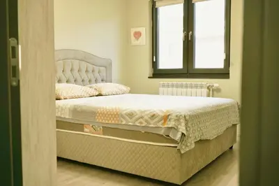 a bedroom with a large bed with a window at Centralside Retreat with Free Parking Spot in Plovdiv