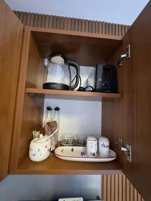 a cupboard with a tea pot and a plate in it at Villa Park Borovets in Borovets