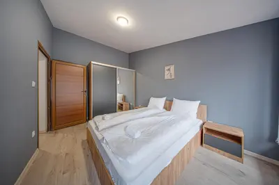 a bedroom with a large bed with white sheets at VEGA Apartments - Metro in Sofia