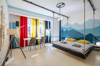 a bedroom with a bed with a mountain mural on the wall at 2 Apartments 15 Seconds from Main street in Sofia