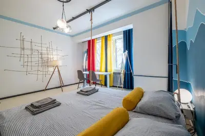 a bedroom with a bed with a yellow head board at 2 Apartments 15 Seconds from Main street in Sofia