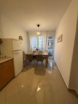 a kitchen with a table and a white refrigerator at 2 Apartments 15 Seconds from Main street in Sofia