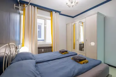 a bedroom with a blue bed with two towels on it at 2 Apartments 15 Seconds from Main street in Sofia