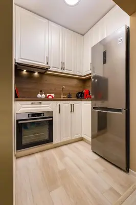 a kitchen with white cabinets and a stainless steel refrigerator at South Beautiful Apartment Vaptsarov in Plovdiv