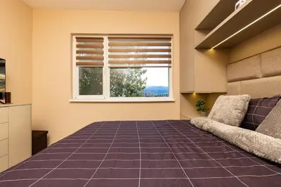 a bedroom with a large bed and a window at South Beautiful Apartment Vaptsarov in Plovdiv