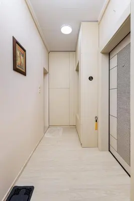 a hallway with white walls and a door at South Beautiful Apartment Vaptsarov in Plovdiv