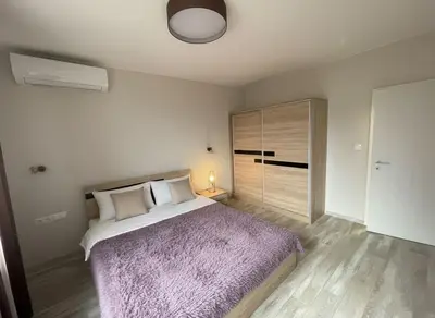 a bedroom with a large bed with a purple blanket at Cozy Central Apartment-Welcome Coffee and Wine in Sofia