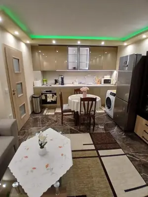 a large kitchen with a table and a refrigerator at Estrella Apartment in Velingrad