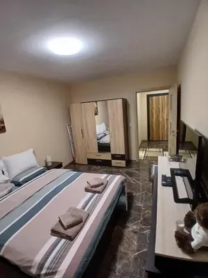 a bedroom with two beds with towels and a tv at Estrella Apartment in Velingrad