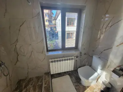 a bathroom with a toilet and a window at Къща за гости Йони in Teteven