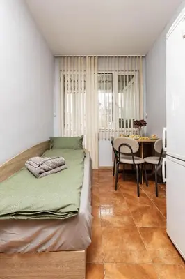 a bedroom with a bed and a table and chairs at Cozy Floor from a House Near the City Center by Flat Mаnager in Plovdiv