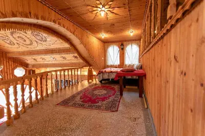 a hallway in a wooden house with a couch and a rug at Къща за Гости Слънце in Breze