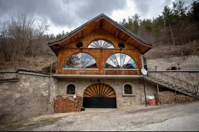 a house with a wooden roof and a large door at Къща за Гости Слънце in Breze