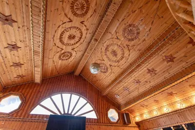 a room with a wooden ceiling with clocks on it at Къща за Гости Слънце in Breze