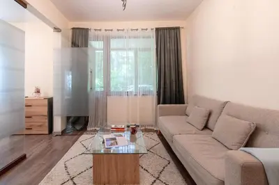 a living room with a couch and a television at Nice 1 BDR apartment next to National Palace of Culture in Sofia