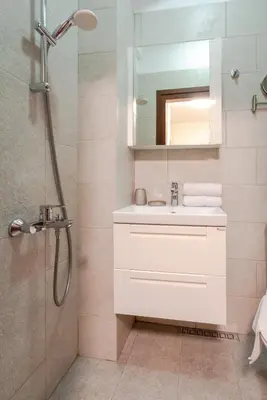 a bathroom with a white sink and a shower at Nice 1 BDR apartment next to National Palace of Culture in Sofia