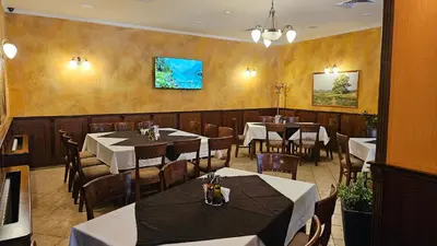 a dining room with tables and chairs in a restaurant at Свети Георги хотел и ресторант in Govedartsi