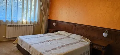 a bedroom with a bed and a window at Свети Георги хотел и ресторант in Govedartsi