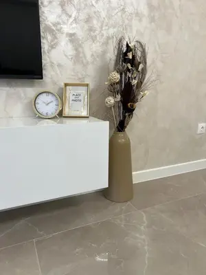 a vase with flowers on a table next to a clock at Le bijou Lauta Forest in Plovdiv
