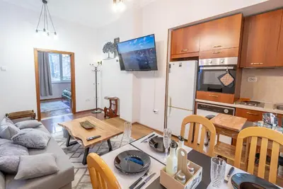 a kitchen and living room with a table and a couch at Two Vintage Apartments by NDK and Vitosha Blvd with Free Parking in Sofia