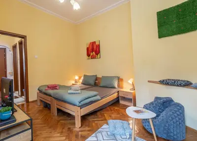 a bedroom with a bed and a tv in it at Two Vintage Apartments by NDK and Vitosha Blvd with Free Parking in Sofia