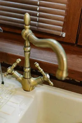 a brass sink faucet on top of a sink at Three Vintage Apartments by NDK and Vitosha Blvd with Free Parking in Sofia