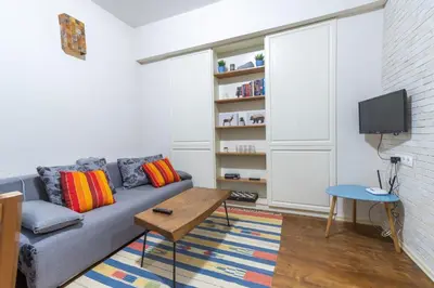 a living room with a couch and a tv at Three Vintage Apartments by NDK and Vitosha Blvd with Free Parking in Sofia