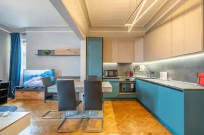 a kitchen with blue cabinets and a table and chairs at Stylish 2BDRM Apartment in the Very Heart of Sofia in Sofia