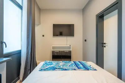 a bedroom with a bed and a tv on the wall at Stylish 2BDRM Apartment in the Very Heart of Sofia in Sofia