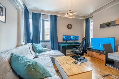 a living room with a couch and a tv at Stylish 2BDRM Apartment in the Very Heart of Sofia in Sofia
