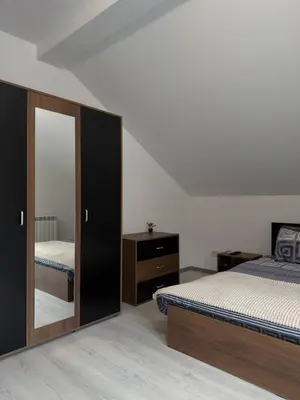 a bedroom with two beds and a mirror at Bianca Guest House Sapareva banya in Sapareva Banya