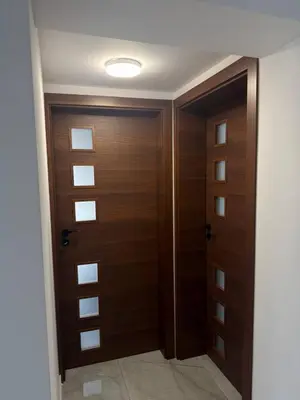 a hallway with two wooden doors in a room at Bianca Guest House Sapareva banya in Sapareva Banya