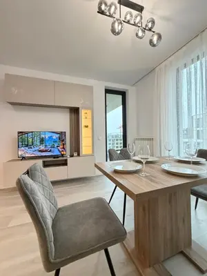 a dining room with a table and chairs and a tv at Cusco Cozy Apt w Parking Spot near Paradise Mall and WiFI in Sofia