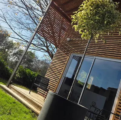 a house with a bench and a tree in front of it at Cottage for 4 people 30 in Sofia