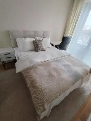 a bedroom with a large bed with white sheets and pillows at AMur Deluxe Apartment in Sofia