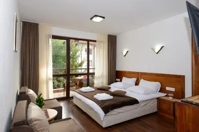 a bedroom with a bed and a large window at Your studio at Winslow Infinity in Bansko
