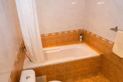 a bath tub in a tiled bathroom with a toilet at Къща за гости Рилски рай in Samokov