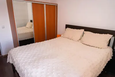 a bedroom with a bed and a mirror at Къща за гости Рилски рай in Samokov