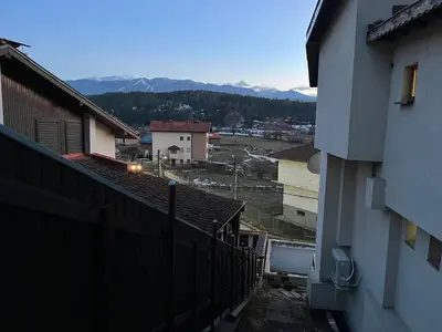 a view of a city with a fence and mountains at Къща за гости Рилски рай in Samokov