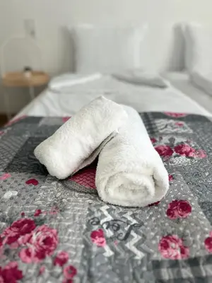 a white towel laying on top of a bed at Къща за гости Касида in Sapareva Banya