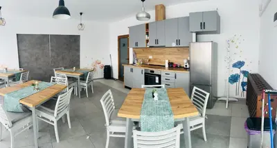 a kitchen with wooden tables and chairs in a kitchen at Къща за гости Касида in Sapareva Banya