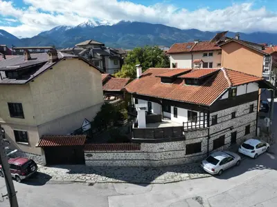 a building with cars parked in a parking lot at White Wolf Chalet in Bansko