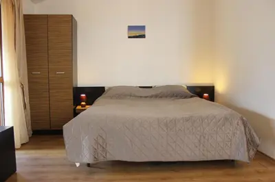 a bedroom with a bed and a dresser at morning in the mountains - apartment in Razlog