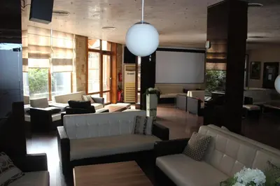 a living room with couches and a projection screen at morning in the mountains - apartment in Razlog
