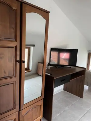 a room with a desk with a mirror and a television at Къща за гости Стиляна in Devin